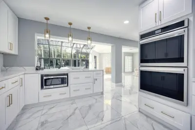 a large white kitchen with white cabinets and appliances at Riverbend Yacht Retreat Waterfront Villa with Pool in Fort Lauderdale