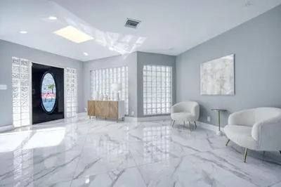 a living room with a marble floor and two chairs at Riverbend Yacht Retreat Waterfront Villa with Pool in Fort Lauderdale