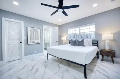 a bedroom with a white bed and a ceiling fan at Riverbend Yacht Retreat Waterfront Villa with Pool in Fort Lauderdale
