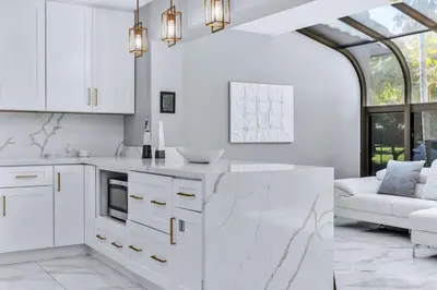 a kitchen with white cabinets and a white couch at Riverbend Yacht Retreat Waterfront Villa with Pool in Fort Lauderdale