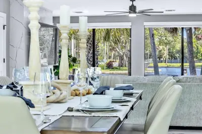 a dining room with a table and a couch at Riverbend Yacht Retreat Waterfront Villa with Pool in Fort Lauderdale