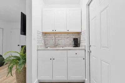 a kitchen with white cabinets and a sink at Miami Modern Studio minutes to Wynwood & Downtown in Miami