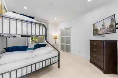 a bedroom with a bunk bed and a dresser at Renovated house w private heated pool grill in Hollywood