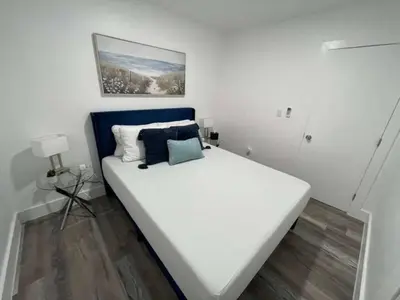 a bedroom with a large white bed with a blue headboard at KING OF MIAMI - 2bd Retreat 1 mile from Brickell in Miami