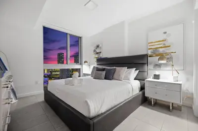 a white bedroom with a large bed and a window at KING OF MIAMI - Downtown Free Parking Pool Gym in Miami