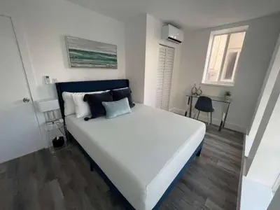 a bedroom with a large white bed with black pillows at KING OF MIAMI - 1 mile from Brickell 2BD Apartment! in Miami