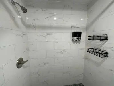 a bathroom with a shower with white marble tiles at KING OF MIAMI - 1 mile from Brickell 2BD Apartment! in Miami