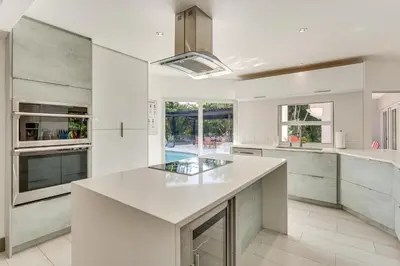 a white kitchen with a large white counter top at Relax in the Sun! Gem 1 Mi to Las Olas Beach in Fort Lauderdale