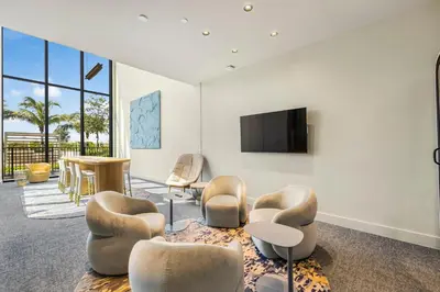 a living room with chairs and a flat screen tv at 72 Park - Miami Beach Condo w Beach Access in Miami Beach