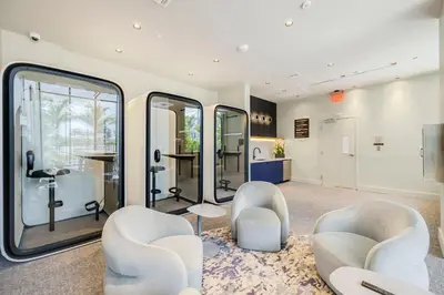 a salon with white chairs and a table and mirrors at 72 Park - Miami Beach Condo w Beach Access in Miami Beach