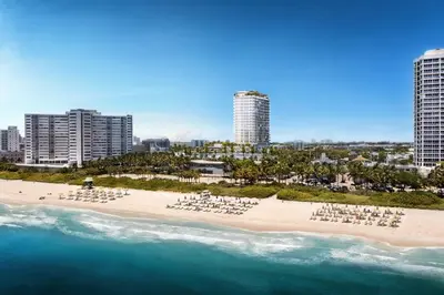 an aerial view of a beach with chairs and the ocean at 72 Park - Miami Beach Condo w Beach Access in Miami Beach