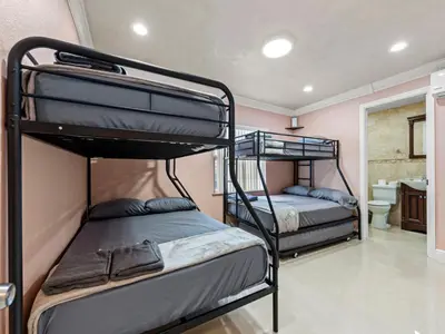two bunk beds in a room with a bathroom at Tropical Bay House-Near By Brickell, Wynwood and South Beach in Miami