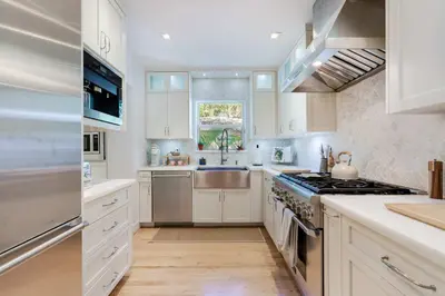 a kitchen with white cabinets and a sink and a stove at Garden Grove- Miami Home with Private Pool in Miami