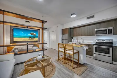 a kitchen and living room with a table and a tv at Alea Miami Designer Studios Downtown in Miami