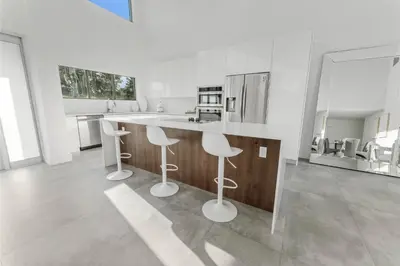 a kitchen with two bar stools and a counter at Villa Coral Bay in Miami Beach