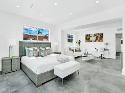 a white bedroom with a bed and a living room at Villa Coral Bay in Miami Beach
