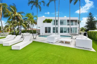 a house with white furniture and green grass at Villa Moonlight Haven in Miami Beach