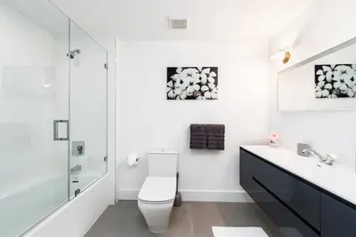 a white bathroom with a toilet and a sink at Villa Modern Miami glamour in Miami
