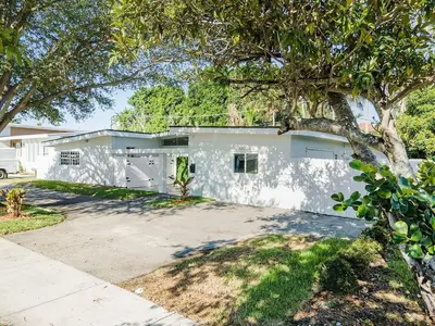 a white house with a tree in front of it at 5BR Villa with Heated Pool, Firepit and 10mins to Beach in Highland Lakes