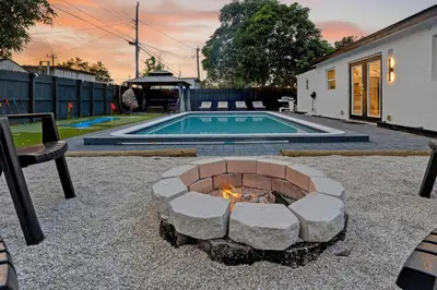 a fire pit in a yard next to a swimming pool at Heated Pool Home - Mini Golf & Soccer & Firepit in Hollywood
