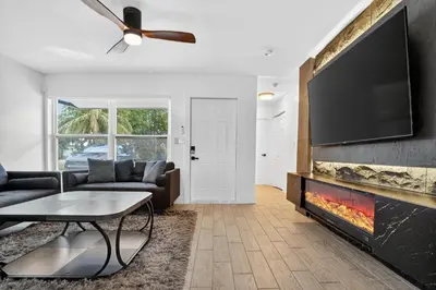 a living room with a fireplace and a flat screen tv at Heated Pool Home - Mini Golf & Soccer & Firepit in Hollywood