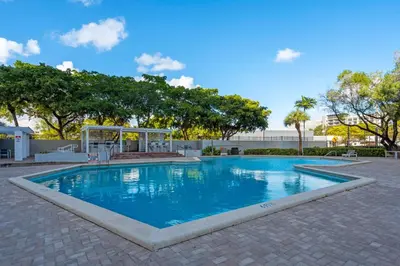 a large swimming pool with blue water in a courtyard at Centrally Located 2 BED in the Heart of NMB in North Miami