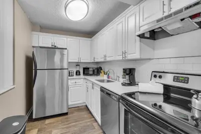 a kitchen with white cabinets and a stainless steel refrigerator at Centrally Located 2 BED in the Heart of NMB in North Miami