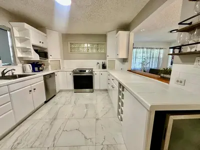 a large white kitchen with white cabinets and appliances at Beach and Downtown Hollywood in Hollywood