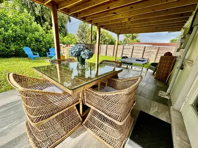 a patio with a glass table and wicker chairs at Beach and Downtown Hollywood in Hollywood