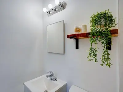 a bathroom with a sink and a plant on the wall at Miami Luxury Studio, Close to Wynwood and Beach in Biscayne Park