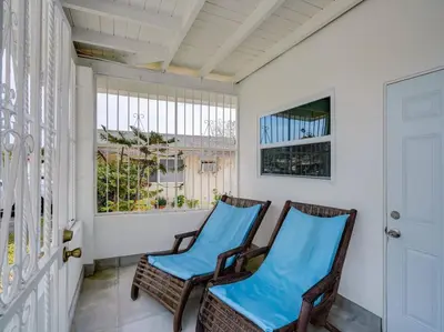 two chairs on a porch with a window at Miami Luxury Studio, Close to Wynwood and Beach in Biscayne Park