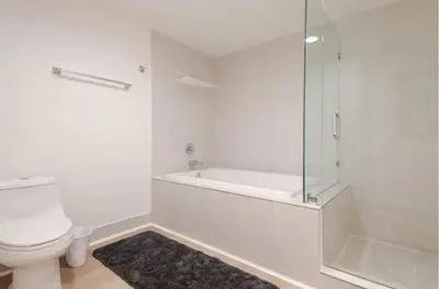 a white bathroom with a shower and a toilet at Beachwalk Resort in Hallandale Beach