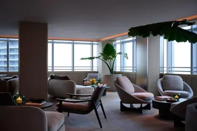 a waiting room with chairs and tables and windows at AKA Hotel Stunning Views w- Free parking in Miami