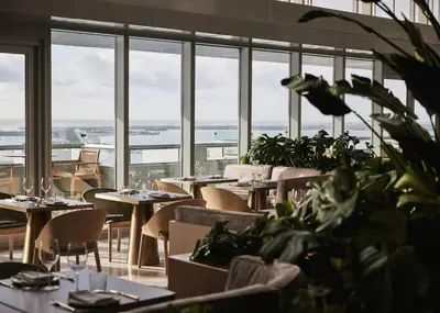 a restaurant with tables and chairs and large windows at AKA Hotel Stunning Views w- Free parking in Miami
