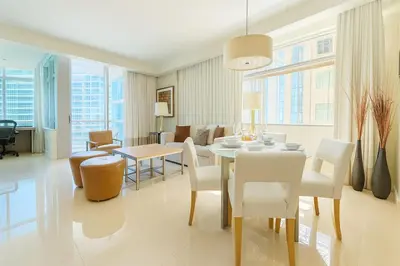 a dining room and living room with a table and chairs at AKA Hotel Stunning Views w- Free parking in Miami