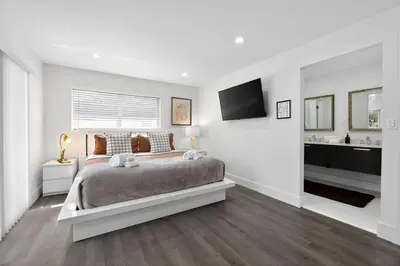 a white bedroom with a bed and a television at 3-BDR Guitar House, Walk to Casino, located close to EVERYTHING! in Fort Lauderdale
