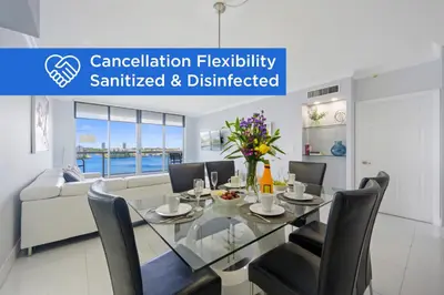 a dining room with a glass table and chairs at Golden Bay 702 in Sunny Isles Beach