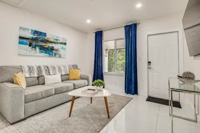 a living room with a couch and a table at Walk to Dining and Nightlife! Chic Apt Near Las Olas in Fort Lauderdale