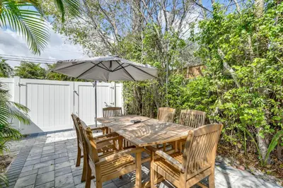 a wooden table with chairs and an umbrella at Walk to Dining and Nightlife! Chic Apt Near Las Olas in Fort Lauderdale