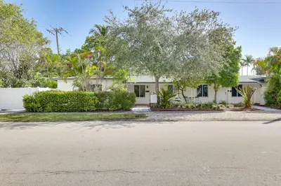 a house with trees in front of a street at Walk to Dining and Nightlife! Chic Apt Near Las Olas in Fort Lauderdale