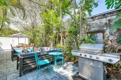 a patio with a grill and a table and chairs at Walk to Dining and Nightlife! Chic Apt Near Las Olas in Fort Lauderdale