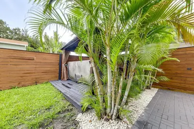 a palm tree in a yard next to a fence at Home in Heart of Wilton Drive, 4 Mi to Beach in Fort Lauderdale