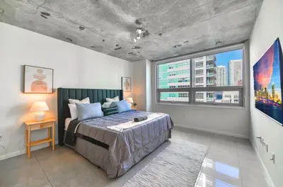 a bedroom with a bed and a large window at Contemporary Midtown Condo - Pool & Free Parking in Miami