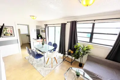 a living room with a glass table and chairs at The Blue Breeze - Parking included in Miami Beach