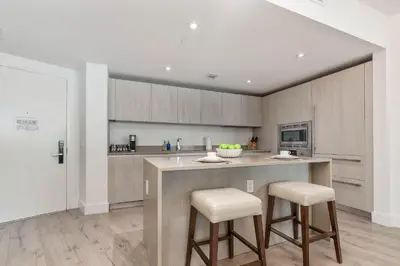 a kitchen with a counter and two stools at Luxurious Beachfront 2-Bedroom 2-Bathroom with balcony Condo at Lyft Resort & Residences - Miami Beach in Hollywood