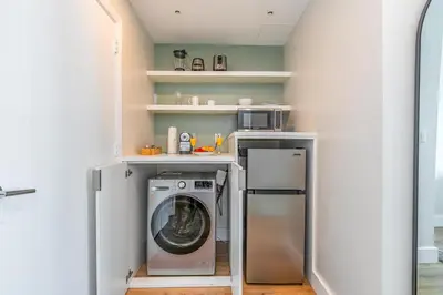a laundry room with a washing machine and a microwave at Coconut Grove Bayview Retreat 2 King Suites Pool Gym and Free Parking in Miami