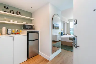 a kitchen with a mirror and a room with a bed at Elevated Grove Escape with Balcony & Bay Views-Includes Parking in Miami