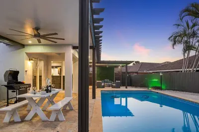 a house with a swimming pool with a dining table and a house at Luxury 5BR Villa Private Pool I Jacuzzi I BBQ I Piano I Near Miami Airport in Kendale Lakes