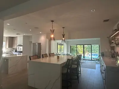 a kitchen with a large island in the middle of a room at Luxury Miami home with heated pool & BBQ area, close to beaches & sports arenas in Miami