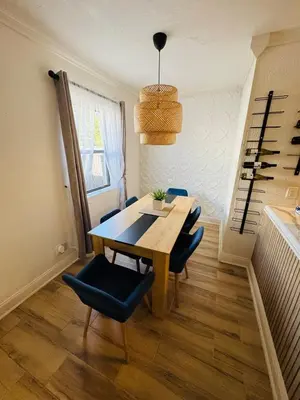 a dining room with a wooden table and blue chairs at Modern Boho 3BR Duplex Escape with Pool & King Bed Near Beach in Fort Lauderdale